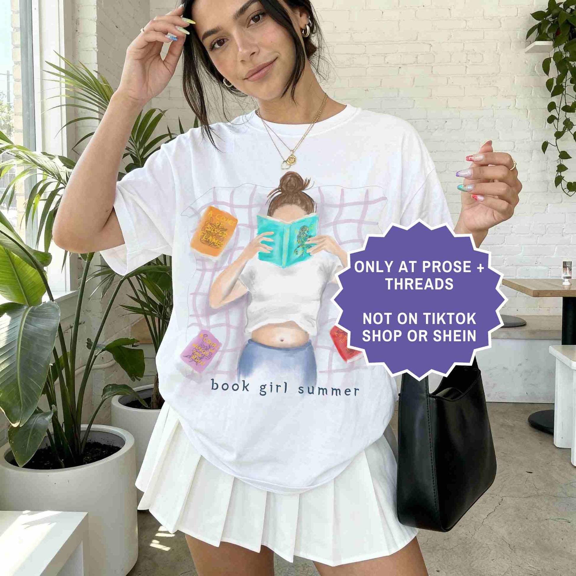 watercolor white shirt featuring a girl reading on a blanket, surrounded by ACOTAR books