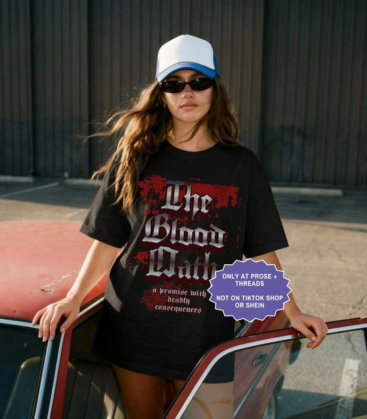 Black fantasy romance shirt inspired by Metal Slinger featuring gothic Blood Oath design with dark romantasy typography and distressed aesthetic