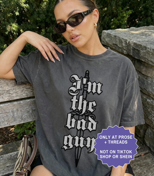 Dark fantasy romance shirt inspired by Metal Slinger featuring gothic “I’m The Bad Guy” quote typography on oversized washed tee