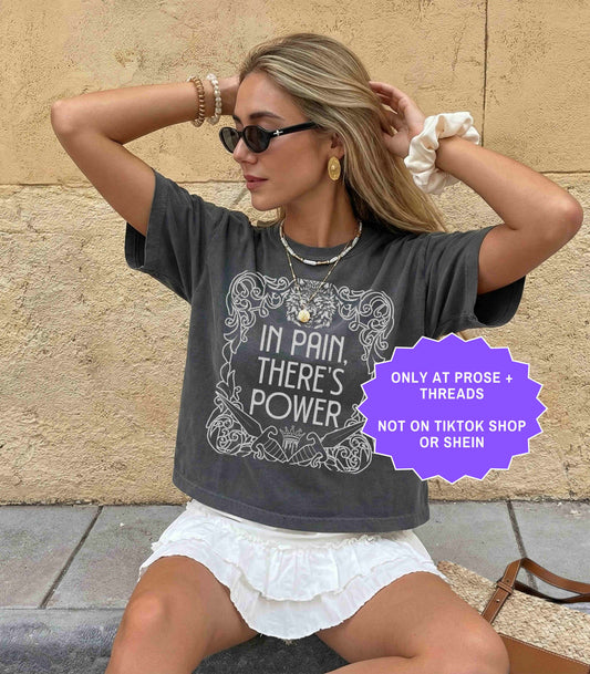Woman wearing In Pain There’s Power Dire Bound romantasy shirt in charcoal